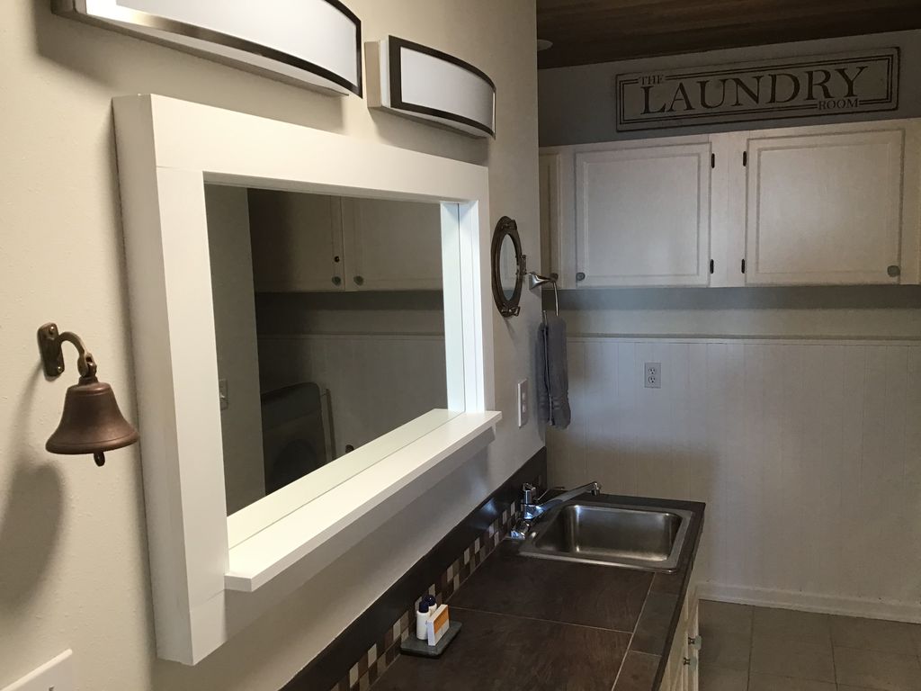 Daylight basement bathroom and laundry area; 2 sinks, washer and dryer, shower.