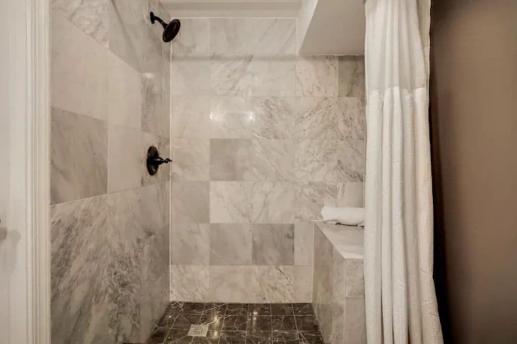 The guest bathroom in the basement has a spacious shower.