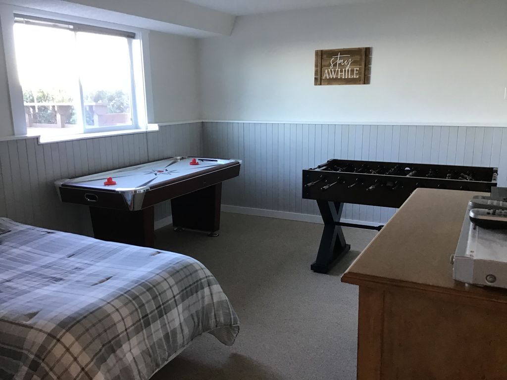 Daylight basement Game Room with 2 twin size beds. Foos Ball, Air Hockey and TV.