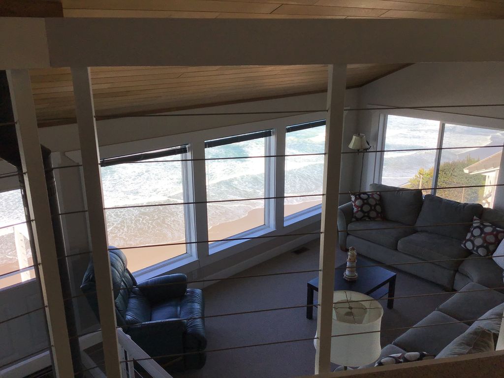 View from 3rd floor loft looking down to the beach sand and ocean.