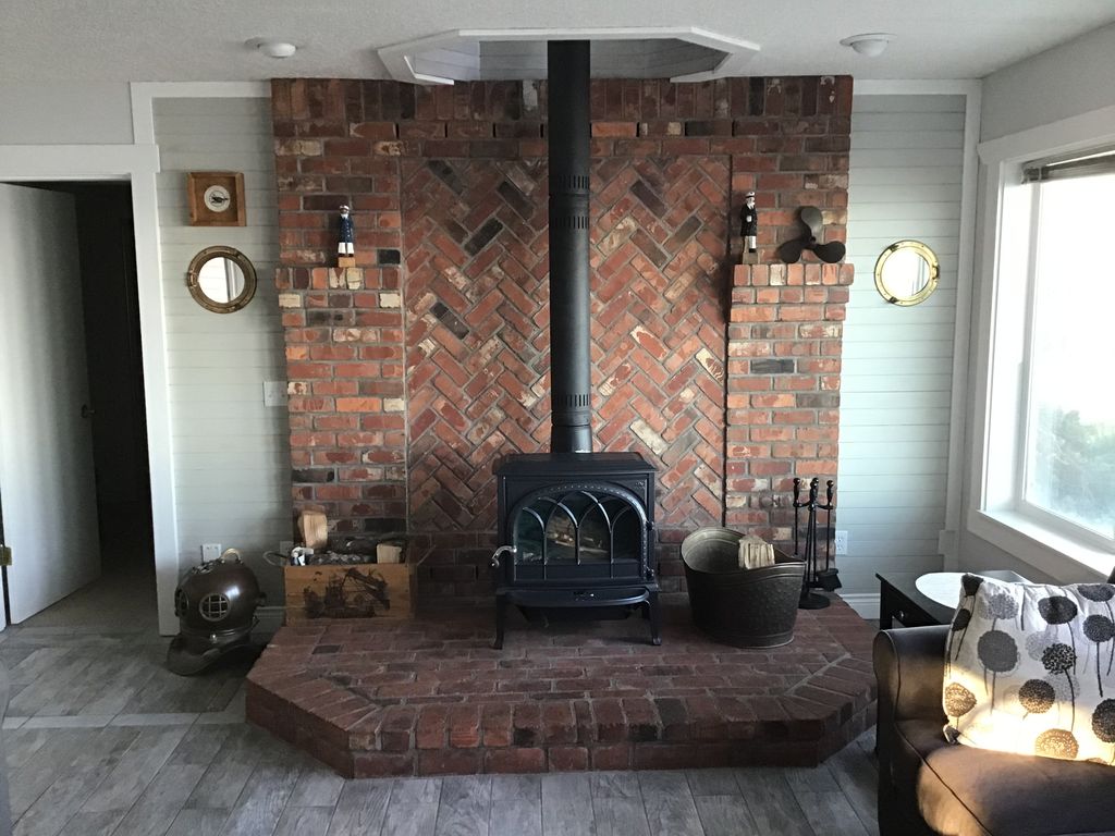 Main level Family Room with wood stove and 4 windows overlooking the ocean.  