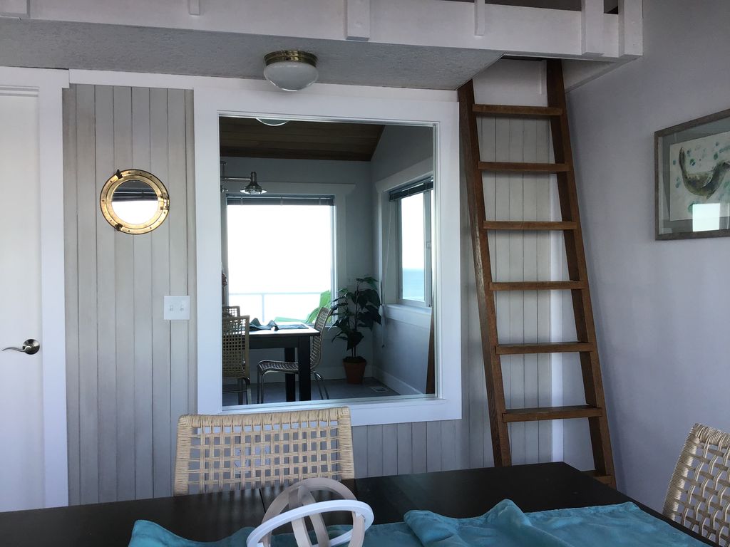 Ladder to the loft area; large mirror reflecting the ocean view.