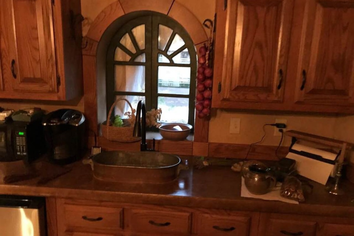 Concrete counter-top, microwave, K-cup coffee maker, Frig and vintage cooker used as a sink. All wood for trim and cabinetry were selectively harvested from our farm!
